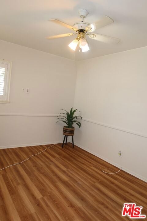 spare room with ceiling fan and wood-type flooring