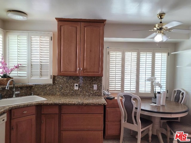 kitchen featuring backsplash, ceiling fan, dishwasher, and sink