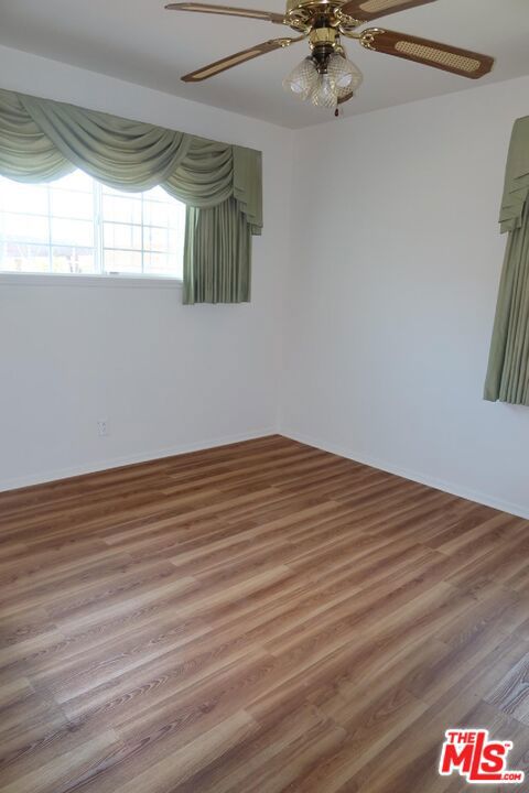 spare room with wood-type flooring and ceiling fan