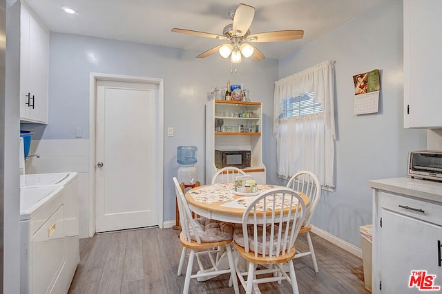 dining room featuring washer and dryer, ceiling fan, and light hardwood / wood-style flooring