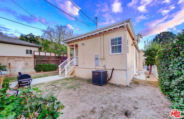 back of house with central AC unit