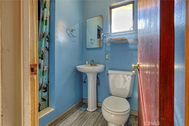 bathroom with a shower with curtain, toilet, and hardwood / wood-style flooring