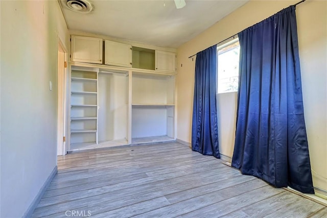 unfurnished bedroom with light wood-type flooring, a closet, and ceiling fan