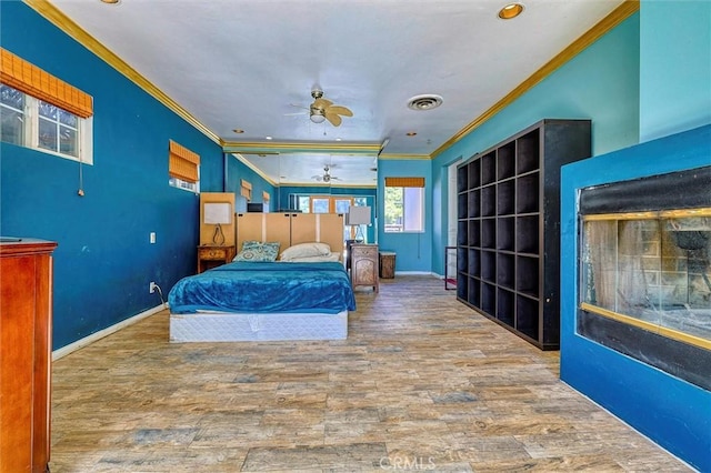 bedroom with hardwood / wood-style flooring, ceiling fan, and crown molding