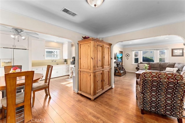 dining space featuring crown molding, ceiling fan, light hardwood / wood-style floors, and a wealth of natural light