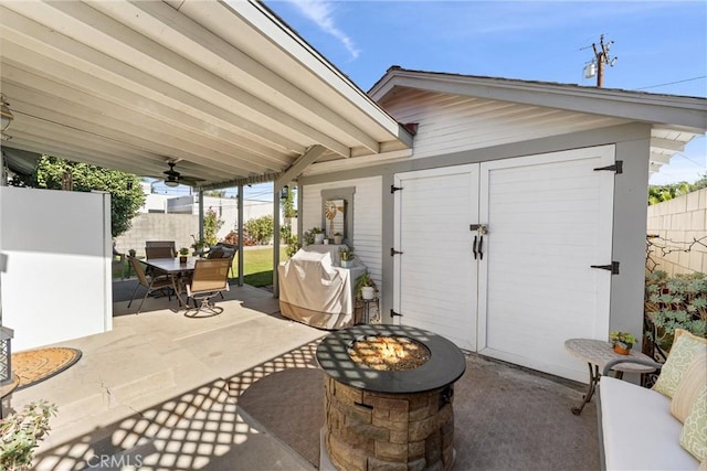 view of patio / terrace with an outdoor structure, area for grilling, and an outdoor fire pit