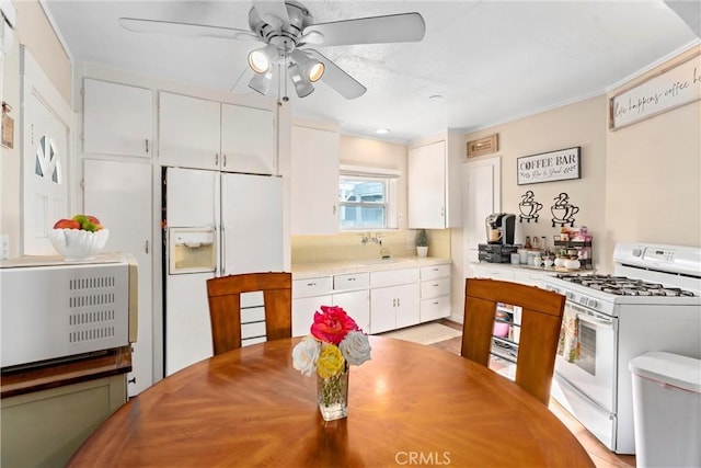 kitchen featuring ceiling fan, white cabinets, and white appliances