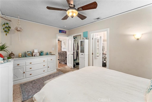 carpeted bedroom featuring ensuite bath and ceiling fan