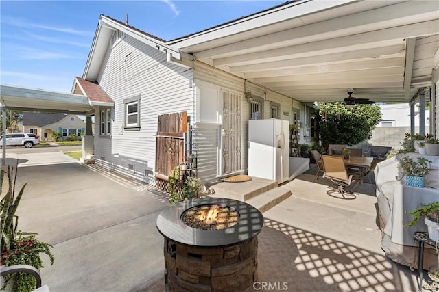 view of patio with ceiling fan and an outdoor fire pit