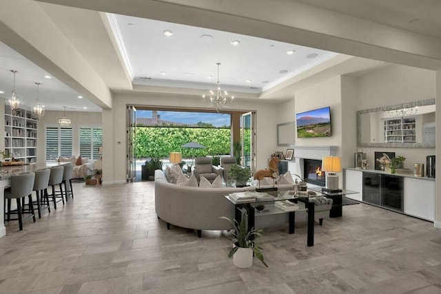 living room with a notable chandelier and a tray ceiling