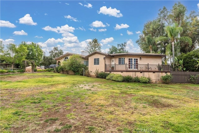 back of property with a yard and a deck