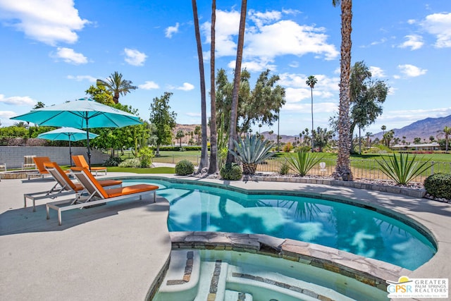 view of swimming pool featuring an in ground hot tub, a mountain view, and a patio