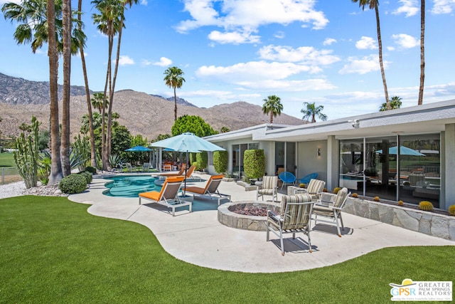 view of patio with a mountain view and an outdoor fire pit