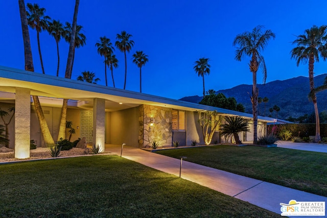 single story home featuring a mountain view and a front lawn