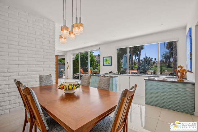 tiled dining space featuring brick wall