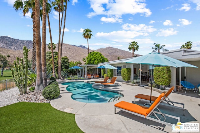 view of swimming pool with a mountain view and a patio area