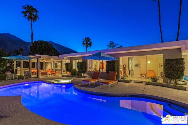 view of pool with a mountain view, a patio area, and an in ground hot tub