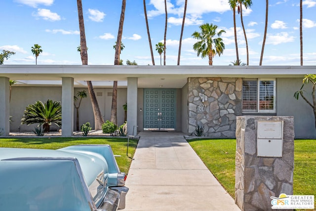 view of exterior entry with a yard