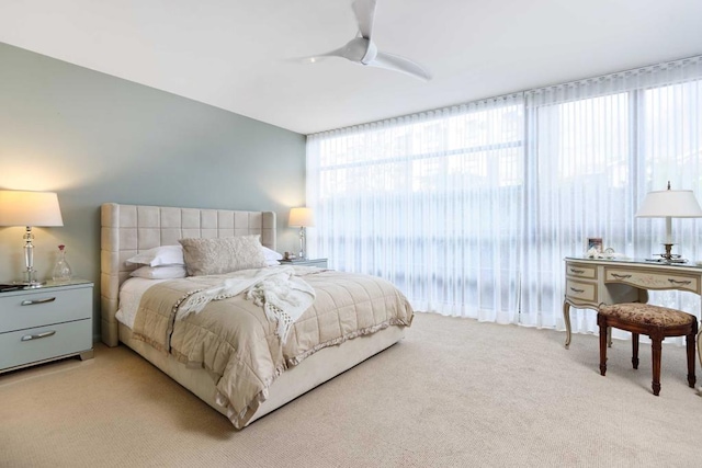 carpeted bedroom with ceiling fan and multiple windows