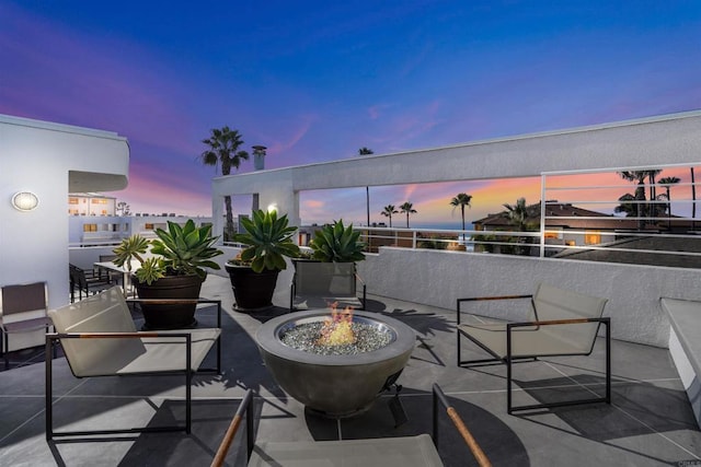 101 Coast Blvd Unit 1C, La Jolla, CA 92037 - patio terrace at dusk with an outdoor fire pit and a balcony