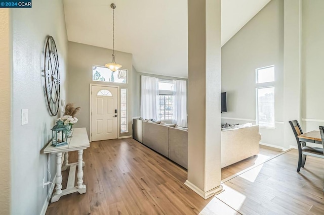 foyer with light hardwood / wood-style floors and high vaulted ceiling