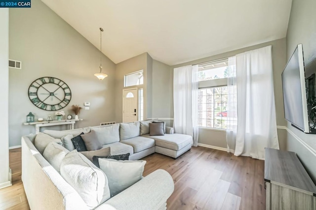 living room featuring light hardwood / wood-style flooring and high vaulted ceiling