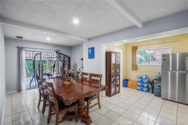 dining room with beamed ceiling, light tile patterned floors, and a textured ceiling