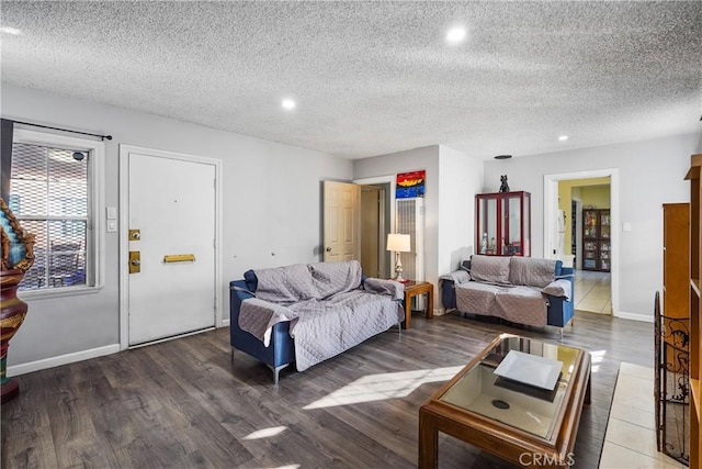 living room with a textured ceiling and dark hardwood / wood-style floors