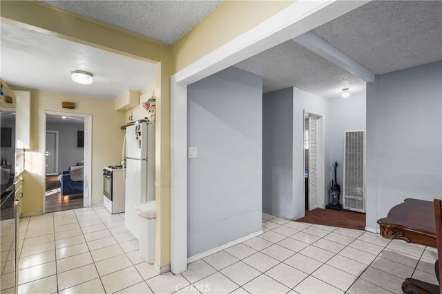 hallway with light tile patterned flooring and a textured ceiling