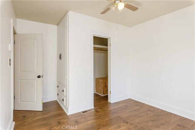 unfurnished bedroom featuring ceiling fan, wood-type flooring, and a closet