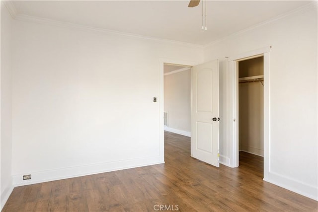 unfurnished bedroom featuring ceiling fan, dark hardwood / wood-style flooring, ornamental molding, and a closet