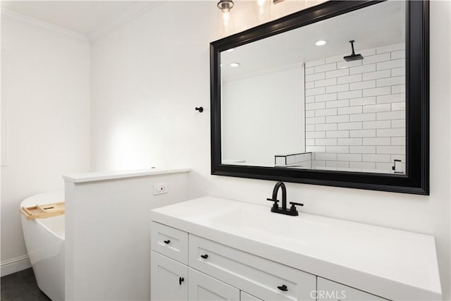 bathroom with a bathing tub, vanity, and ornamental molding