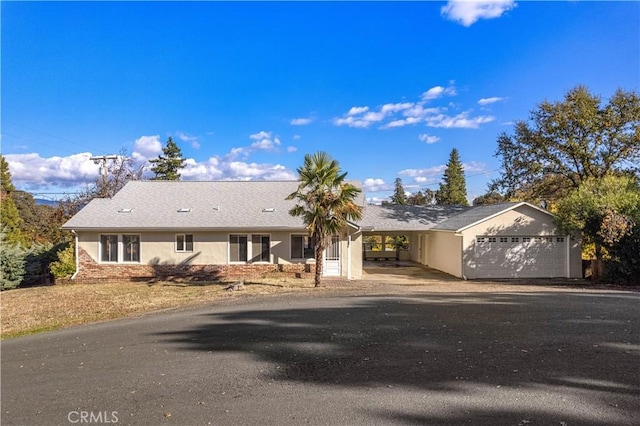 single story home featuring a garage and a carport