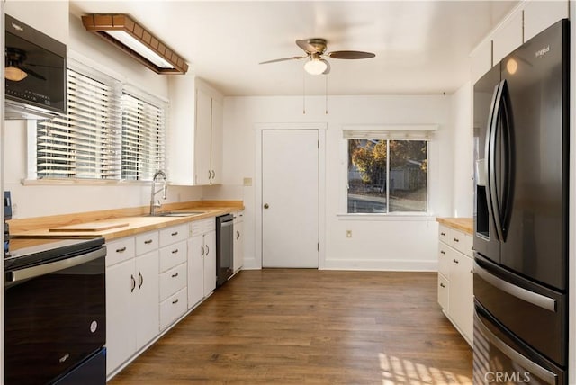 kitchen featuring black appliances, butcher block countertops, white cabinetry, and sink