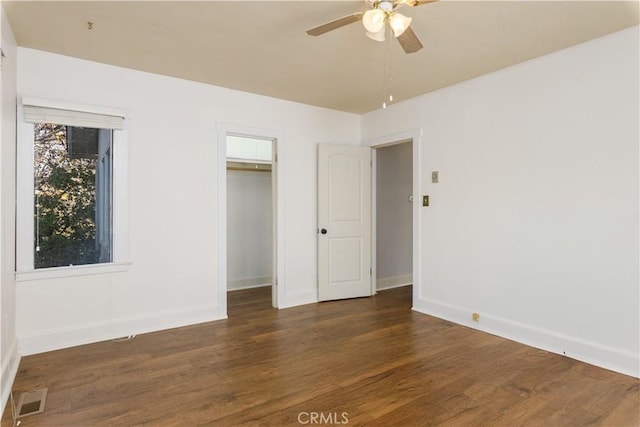 unfurnished bedroom featuring ceiling fan, dark hardwood / wood-style floors, and a closet