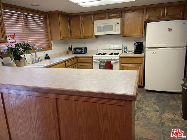 kitchen with kitchen peninsula, white appliances, and sink