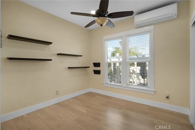 empty room with an AC wall unit, ceiling fan, and light hardwood / wood-style floors