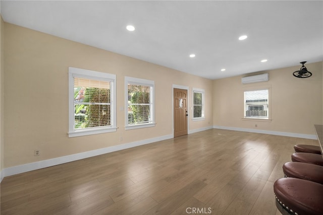 living room with a wall mounted AC and wood-type flooring