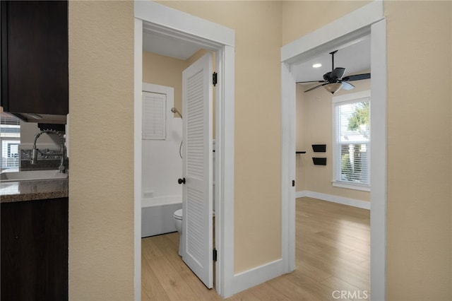 hall featuring light hardwood / wood-style flooring and sink