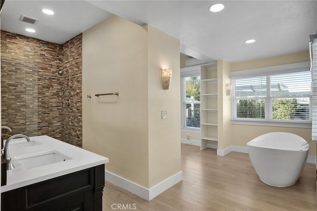 bathroom with separate shower and tub, hardwood / wood-style floors, and vanity