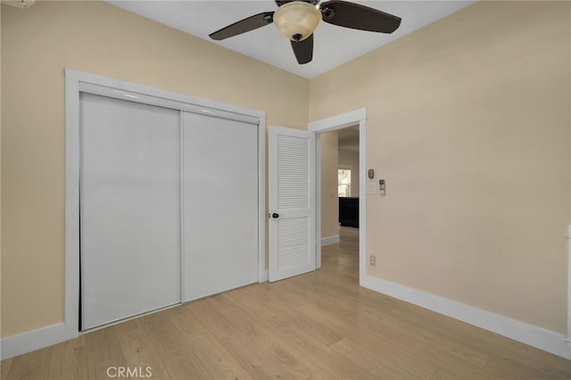 unfurnished bedroom featuring a closet, light hardwood / wood-style floors, and ceiling fan