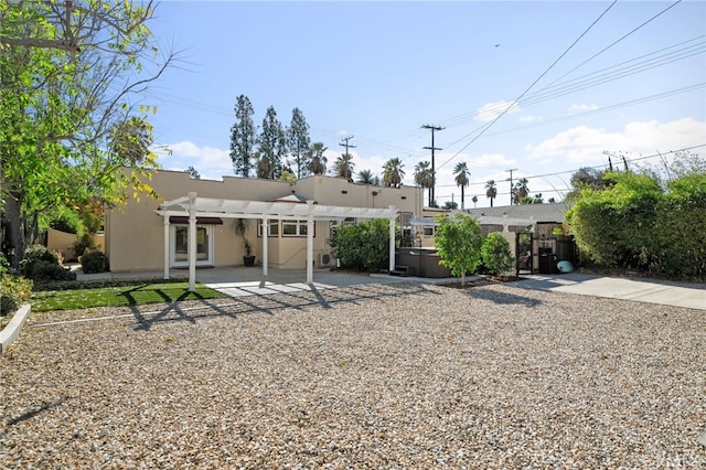 back of property featuring a pergola, a patio, and a hot tub