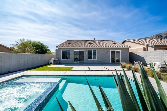 rear view of house with a fenced in pool