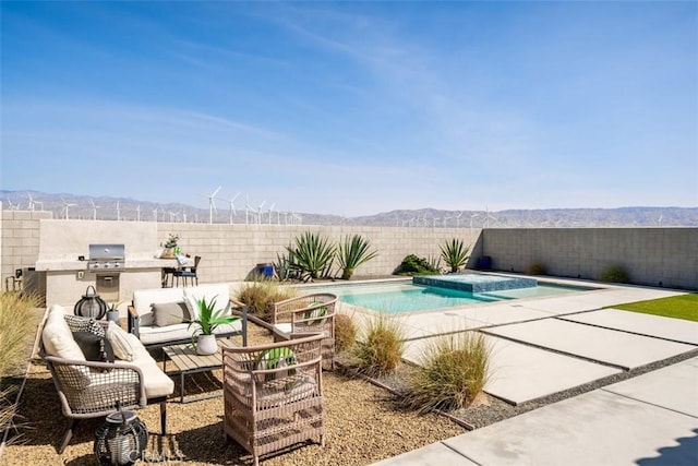 view of swimming pool with a mountain view, a grill, a patio area, and an outdoor hangout area