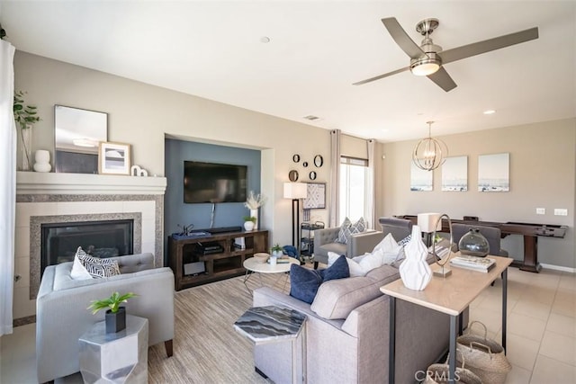 living room featuring light tile patterned floors and ceiling fan with notable chandelier