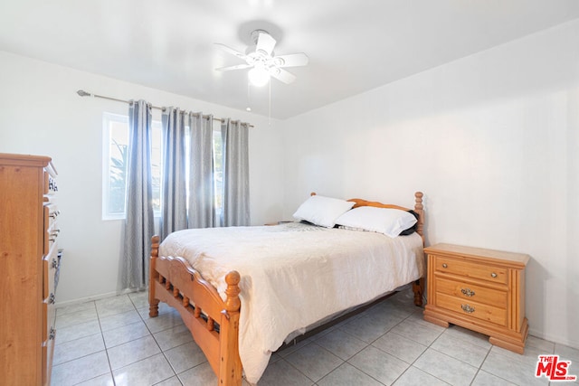 tiled bedroom featuring ceiling fan