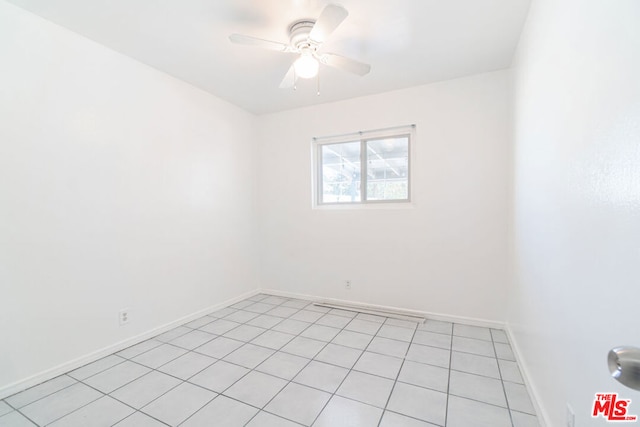 spare room with ceiling fan and light tile patterned floors