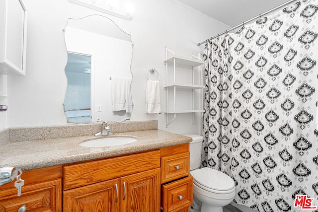 bathroom with walk in shower, vanity, and toilet