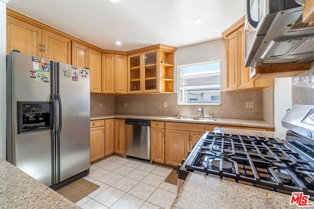 kitchen featuring tasteful backsplash, sink, light tile patterned floors, and stainless steel appliances