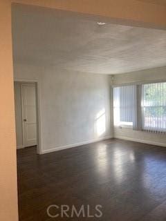 unfurnished room featuring dark wood-type flooring